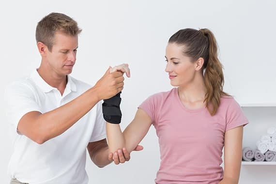 physiotherapist helping woman with wrist brace carpal tunnel
